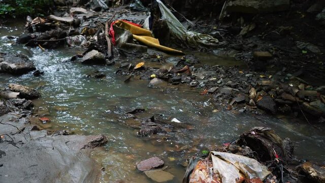 Garbage pile in a polluted forest. Dump plastic bottles, bags, cans. The concept of environmental pollution and environmental catastrophe.
