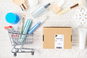 winter flat lay with cosmetics, parcel and snowflake