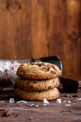 Organic food snack tasty sweet dessert milk dark chocolate chip salt cookie closeup piece fruit orange raspberry hazelnut nuts cinnamon on cocoa cacao powder wooden table for new year Christmas gift