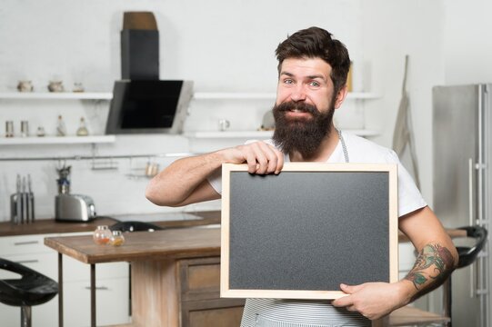 smiling brutal bearded man chef hold blank board for copy space, announcement