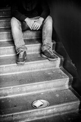 A paper plate of bread stands on a concrete staircase stands, in the background a homeless man
