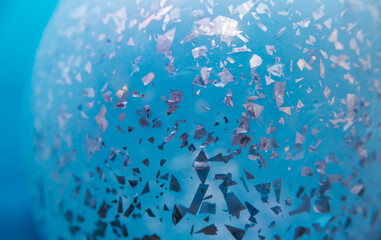 Abstract background texture, bright holographic shaped metal foil ornament inside the balloon.