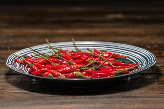 Fresh Red Birds Eye Chilli in a plate on a wooden table