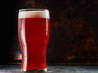 a glass of red ale beer, rusty iron background copy space