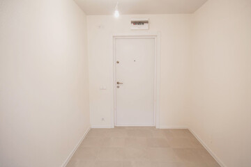 empty light room in a new building, with white walls and door