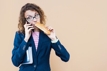 Multifunctional, multitasking business lady is talking on phone, eating on go. Young woman girl in...