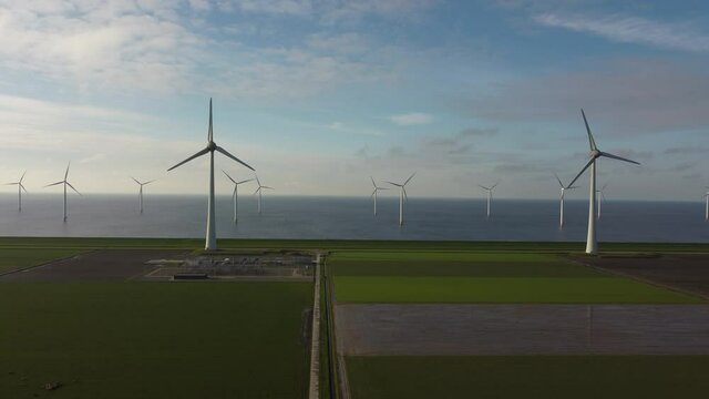 Aerial view on wind turbines on a levee and off the coast of Flevoland on the IJsselmeer coast in The Netherlands
