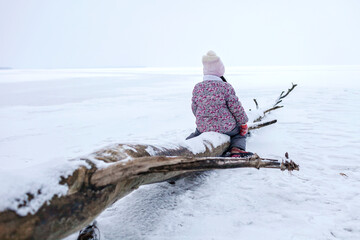 School age girl have fun on the frozen lake and enjoying winter season. Winter, silence and wild nature, active winter weekend, seasonal outdoor activities, happy family lifestyle, copy space