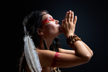 indian woman immerse herself in hypnosis, shamaning alone isolated in studio, side view