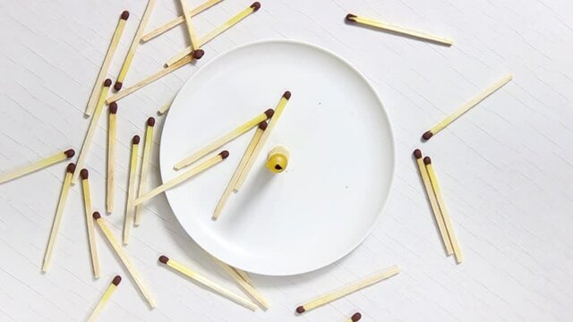 A small candle stub in a white candlestick, near which matches are scattered. The view from the top.