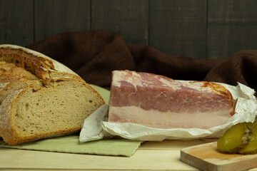 Pork tenderloin lard with meat on a wooden background with space for text