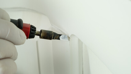 restoration of wooden surfaces, master seals the scratch on the white door close-up