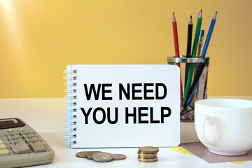 We Need You HELP is written on a notepad