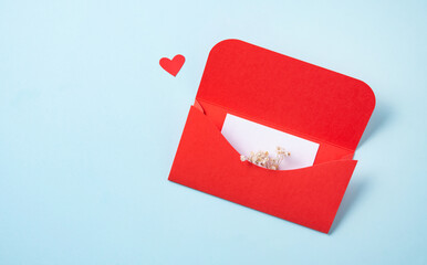 Red envelope with white letter and flowers  on a gray background. The concept of Valentine's Day