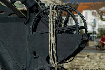 Vendée, France; January 15, 2021: photo of the cogwheels and rope of a crane on the quayside of the port of Noirmoutier in the island.