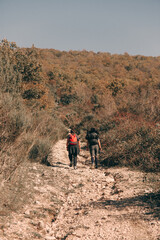 Obraz premium Two young friends go trekking in the mountains during the autumn time
