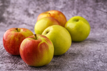 Green and red apples on blackboard or chalkboard background. Close-up on a gray background.Ideal food for diet.