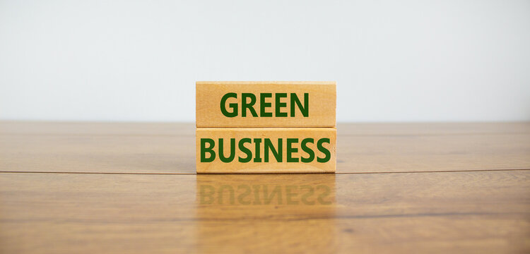 Green business symbol. Wooden blocks form the words 'green business' on beautiful wooden table, white background. Business, ecological and green business concept. Copy space.