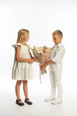 Studio portrait boy gives girl festive bouquet, congratulatory concept, white background, copy space