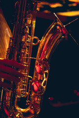 Fototapeta na wymiar A brass saxophone is played inside of a dark club. 