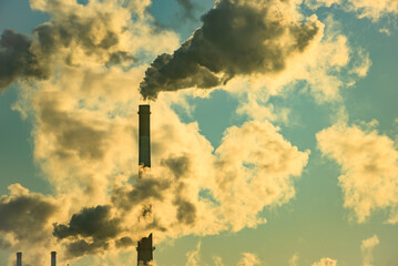 Factory pipe polluting air, smoke from chimneys against sun, environmental problems, ecological...