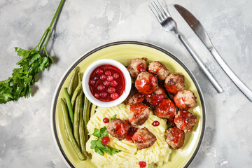 Swedish meatballs with mashed potatoes and green beans on concrete background