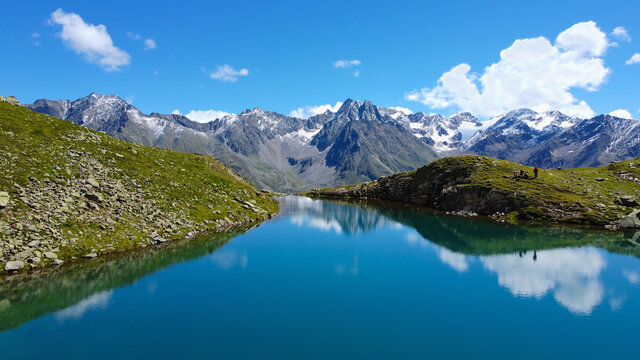 Perler See Bergsee in den Alpen, Berge mit See und blaues Wasser in Felsen mit Grün und Schnee beim Wandern für eine Auszeit und Erholung bei blauem Himmel © Lukas Meierheinrich