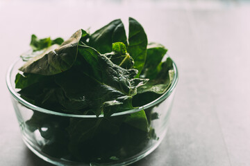 Glass bowl of fresh spinach leaves