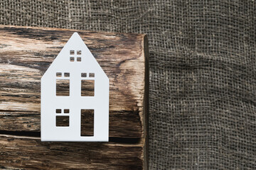 A dry piece of log with cracks and a metal layout of the house
