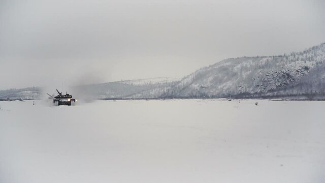 Snow-covered shooting range field in the highlands. Tanks go for testing