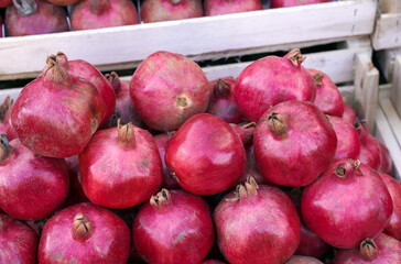Fototapeta na wymiar Fresh ripe red pomegranate in wooden boxes 