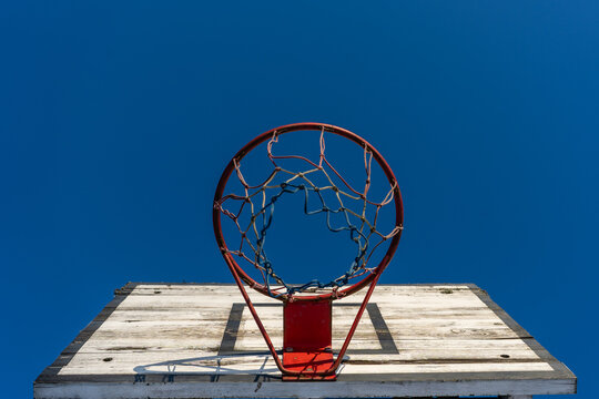 The bottom-up view of the basketball hoop against the backdrop of a mole is a blue winter sky