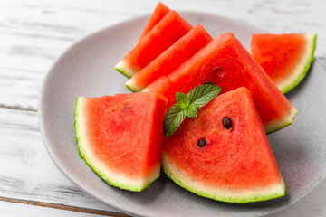 Fresh watermelon fruit slices against white wooden background