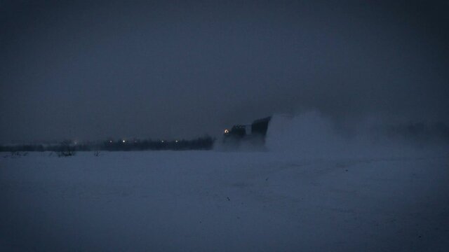 Shooting range Russia.Military tractor machine moves along a snowy field at nigth