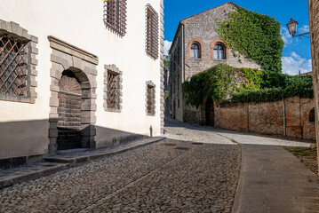 The medieval village of Monselice, walk towards the castle, on a day with blue sky, clouds, detail of the brick buildings of the stone road. Padua, Veneto.Italy.
