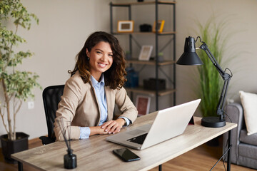 Portrait of a young business woman sitting at a desk in the office