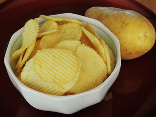 Potato chips with cheese in a cup on the table.