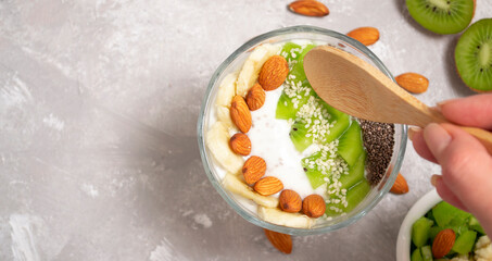 Chia seed pudding bowl, vegan dessert with kiwi, banana and coconut milk. Overhead, top view, flat lounger