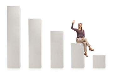 Young blond woman with glasses sitting on a white column chart and waving