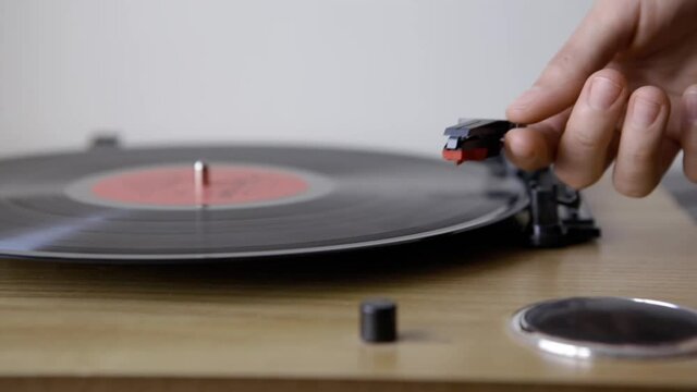 Vinyl Turntable Gramophone Record. Included gramophone and torque plate close-up on a light background.  Hand puts and takes of  LP needle on record. Includes authentic vinyl crackling sound
