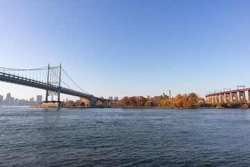 The Triborough Bridge over the East River with the Shore of Randalls and Wards Islands during Autumn with Colorful Trees in New York City