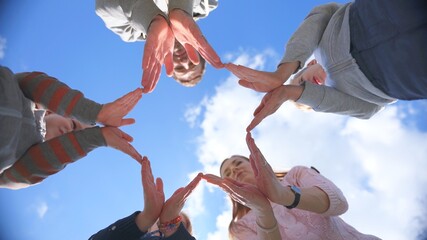 A friendly family makes a star shape out of their hands.