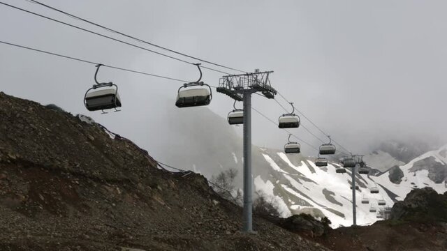 RUSSIA, ROSA KHUTOR - JUNE 11, 2016: Mountain resort Krasnaya Polyana, the cable car, cottages and hotels, high mountains, snowy peaks and clouds