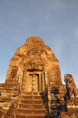 Warm golden hour light on the temples at Angkor Wat complex in Cambodia