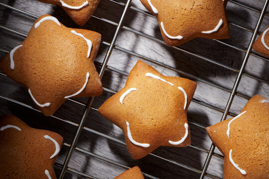 Freshly baked star shaped ginder cookies on cooling rack.