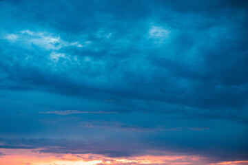Naklejka na ściany i meble Very beautiful landscape of the evening sky with clouds, sunset. Blue, orange sky.