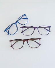 Progressive glasses with different colored frames on a white table
