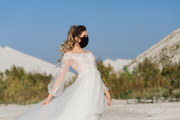 Fototapeta na wymiar Bride in wedding dress with medical mask at coronavirus covid-19 quarantine period.