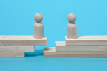 Wooden figures separated by a gap. Concept of separation, lack of communication, crisis, division....