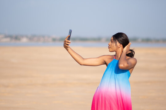 beautiful african lady taking selfies at the beach